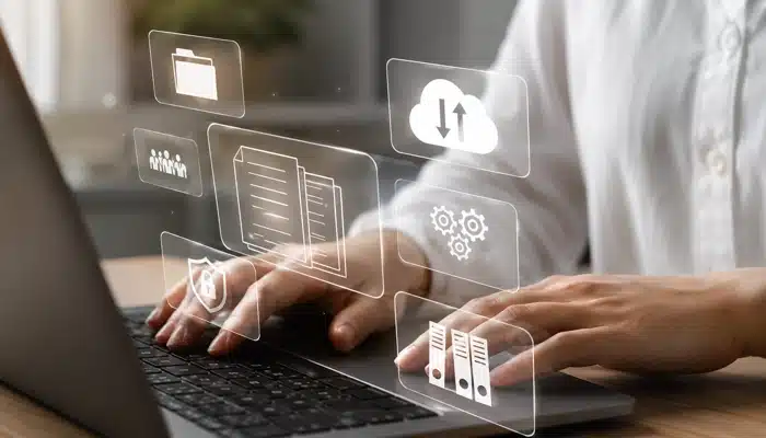 Pessoa operando notebook com ícones de dados, representando a integração ERP Consinco VTEX